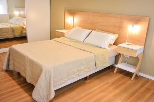 um quarto com uma cama grande e uma mesa de cabeceira com um candeeiro em Studio Congreso em Buenos Aires