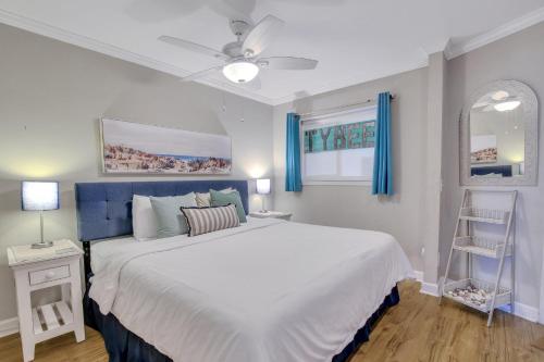 a bedroom with a large white bed with blue curtains at Hamlet's Passion Beach in Tybee Island