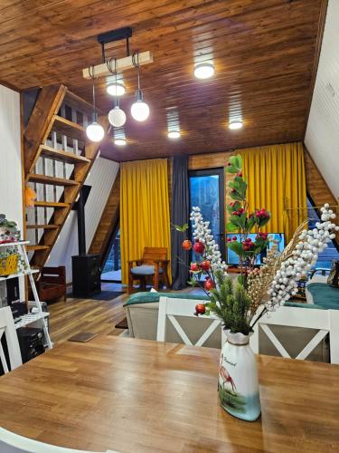 a room with a table with a vase of flowers on it at B&B Cottage in Mestia in Mestia