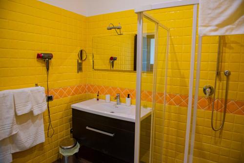 a yellow bathroom with a sink and a shower at ARTEMIDE "Fiore Club" B&B SUITE SPA in Giffoni Valle Piana