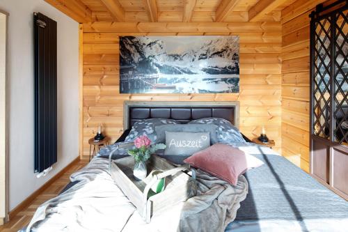 ein Schlafzimmer mit einem Bett in einer Holzwand in der Unterkunft Ferienhaus Auszeyt für Zwei in Waldeck