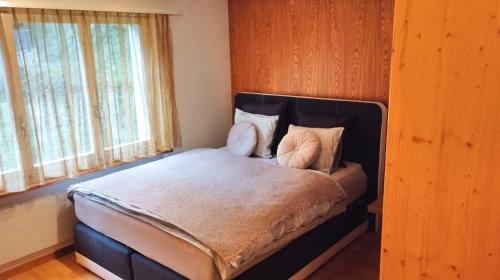 Schlafzimmer mit einem Bett mit einem schwarzen Kopfteil in der Unterkunft 5Min Walk To Audi FIS Ski World Cup Swiss Studio in Adelboden
