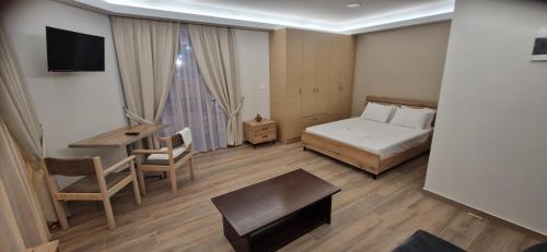 a bedroom with a bed and a table and a desk at Hotel Antirriο in Antirrio