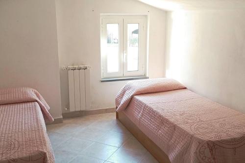 een slaapkamer met 2 bedden en een raam bij Casa Mariel in La Spezia