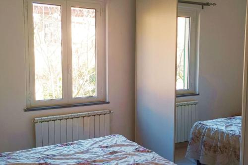 een slaapkamer met 2 ramen en een bed erin bij Casa Mariel in La Spezia