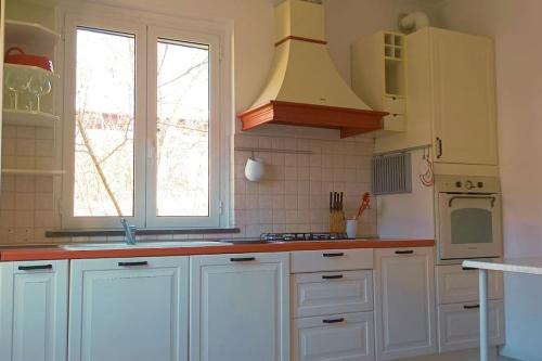een keuken met witte kasten en een fornuis met oven bij Casa Mariel in La Spezia