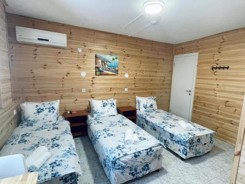 Duas camas num quarto com paredes de madeira em Amigo Hotel On The Beach em Nahariya