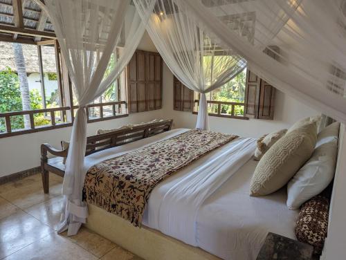 a bedroom with a bed with white sheets and windows at Unique 3BR Villa with Pool 5 minute walk to the Pererenan beach in Canggu