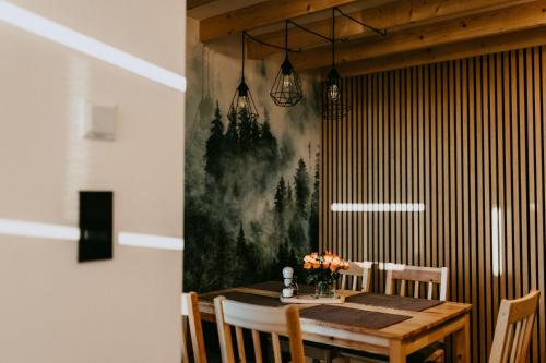 una mesa de comedor con una pintura en la pared en Domki pod Kamionna, en Laskowa