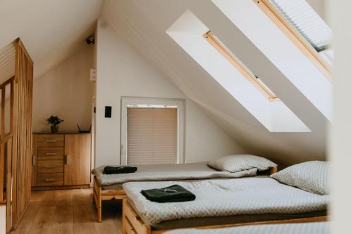 a attic bedroom with two beds and a window at Domki pod Kamionna in Laskowa
