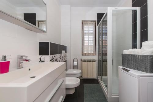 a white bathroom with a toilet and a sink at Casa Bruna in Labin