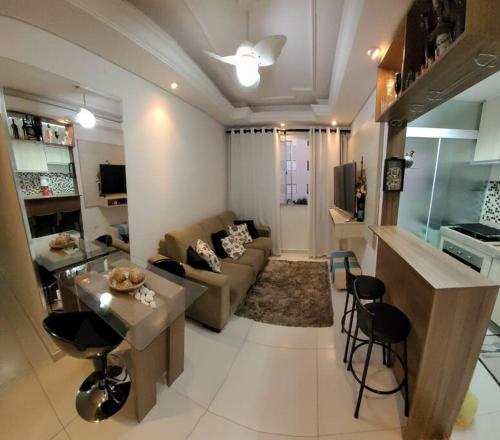 a living room with a couch and a table and a kitchen at Apto mobiliado -48m² próximo ao shopping Iguatemi in Votorantim