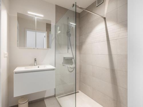 ein Bad mit einer Glasdusche und einem Waschbecken in der Unterkunft Winoc 302 luxury family apartment on the dike in Koksijde