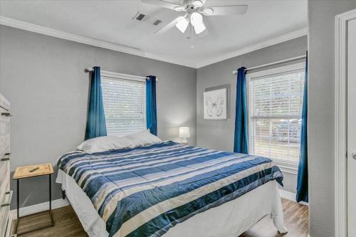 sypialnia z łóżkiem z niebieskimi zasłonami i wentylatorem sufitowym w obiekcie Charming 3 bedroom home in Nederland w mieście Nederland