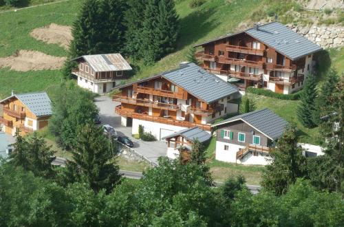 un groupe de maisons sur une colline avec des arbres dans l'établissement Appartement près du village, 7 personnes, 2 chambres, 1 mezzanine - CC08, à Beaufort