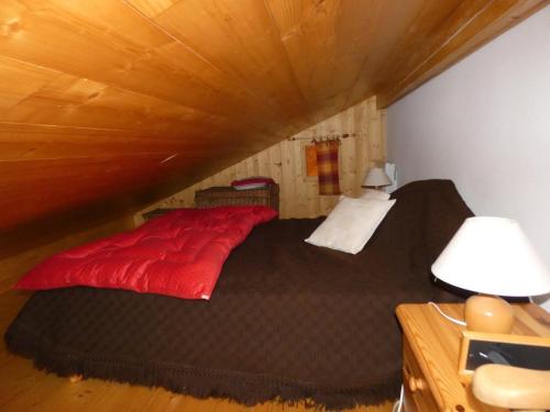 ein Schlafzimmer mit einem roten Bett im Dachgeschoss in der Unterkunft Appartement près du village, 7 personnes, 2 chambres, 1 mezzanine - CC08 in Beaufort
