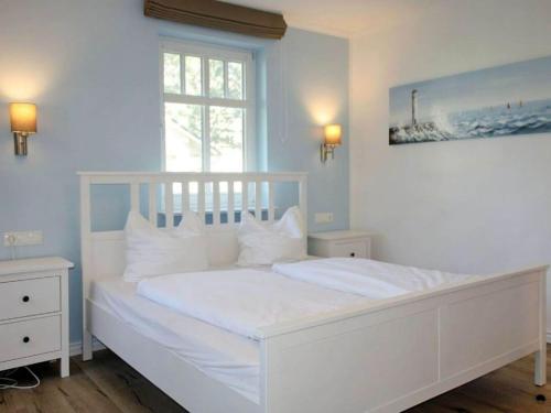 - un lit blanc dans une chambre avec fenêtre dans l'établissement Comfy apartment with 1 bedroom and balcony 134, à Binz