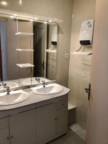 une salle de bain avec deux lavabos et un grand miroir dans l'établissement Appartement Les Bons Vivants au coeur de Perrigny, à Perrigny-sur-Loire