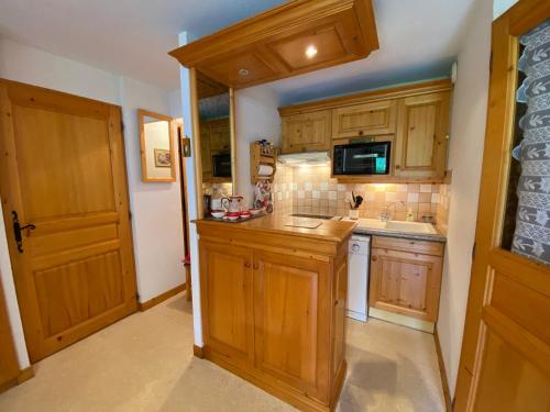 une cuisine avec des armoires en bois et un évier dans l'établissement Appartement pied des pistes, 4 personnes, 1 chambre, 1 coin montagne - GRAN06, à Beaufort