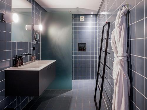 a blue tiled bathroom with a sink and a shower at Parc Broekhuizen l Culinair landgoed in Leersum
