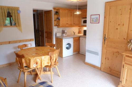 une cuisine avec une table en bois et un lave-linge dans l'établissement Appartement cosy, 4 personnes, 1 chambre, 1 coin montagne - CC07, à Beaufort
