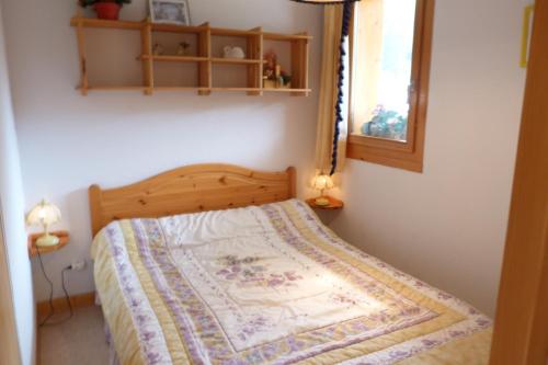 un lit avec une couette dessus dans une chambre dans l'établissement Appartement cosy, 4 personnes, 1 chambre, 1 coin montagne - CC07, à Beaufort