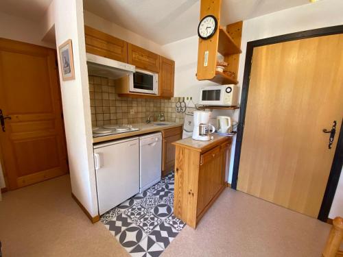 une petite cuisine avec un réfrigérateur et un micro-ondes dans l'établissement Appartement lumineux, 4 personnes, 1 chambre - OCII10, à Beaufort