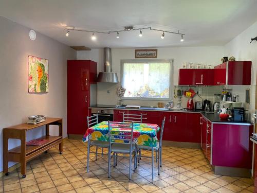 une cuisine avec des armoires rouges et une table et des chaises dans l'établissement Appartement spacieux et confortable, 11 personnes, 4 chambres, 1 garage - ROCHE02, à Beaufort