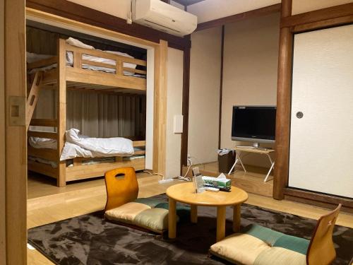 a living room with two bunk beds and a table at わがらん家 -えんつなぎ- in Kumano
