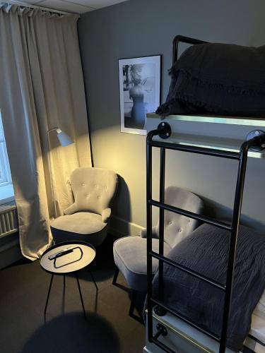 a bedroom with a bunk bed and a chair at Hotell Carl Friman in Motala