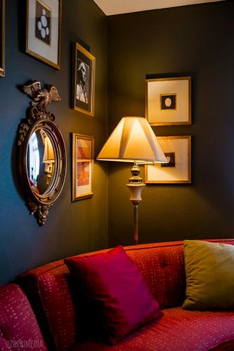 a living room with a couch and a mirror and a lamp at The George Washington on Mt Washington in Pittsburgh