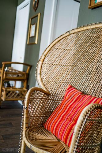 a brown wicker chair with a red pillow on it at The George Washington on Mt Washington in Pittsburgh