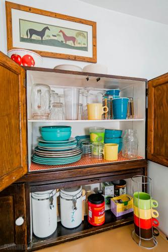 a cabinet filled with dishes and bowls and plates at The George Washington on Mt Washington in Pittsburgh
