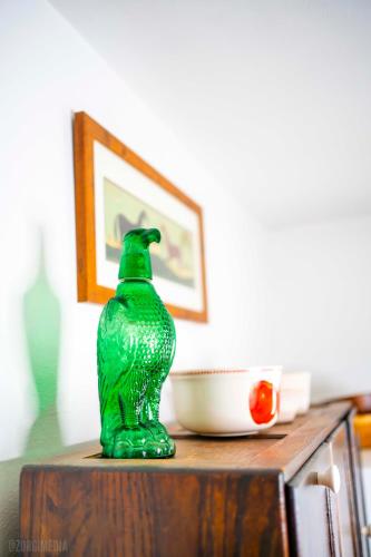 a green glass vase sitting on top of a table at The George Washington on Mt Washington in Pittsburgh