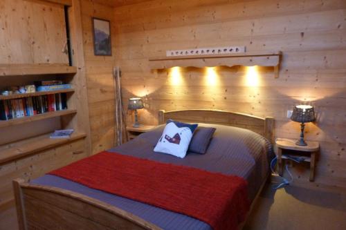 um quarto com uma cama num chalé de madeira em Appartement centre village, 6 personnes, 2 chambres - VLII71 em Beaufort