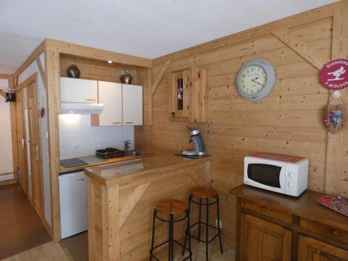 une cuisine avec un comptoir, un four micro-ondes et une horloge dans l'établissement Appartement cosy, 4 personnes, 1 coin montagne - AR2005, à Beaufort