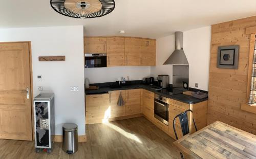 une cuisine avec des armoires en bois et un four à plaques de cuisson dans l'établissement Appartement cosy, 6 personnes, 2 chambres - SOURCES201, à Beaufort