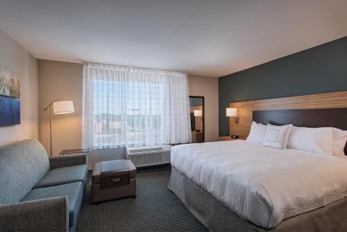 a hotel room with a large bed and a couch at TownePlace Suites by Marriott Lakeland in Lakeland