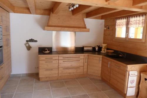 a large kitchen with wooden cabinets and a stove at Chalet ambiance montagne, 10 personnes, 4 chambres - CH15 in Beaufort