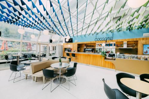 Un restaurante con mesas y sillas y un bar. en FIAP Paris, en París