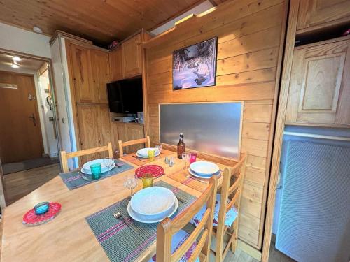 une salle à manger avec une table, des chaises et une télévision dans l'établissement Studio 4 pers, proximité commerces et pistes, parking, terrasse Ouest, piscine l'été - Méribel - FR-1-180-608, à Les Allues