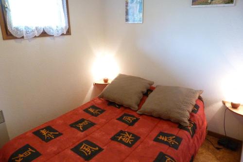 une chambre avec un lit avec deux oreillers dessus dans l'établissement Appartement centre, 4 personnes, 1 chambre, 1 coin montagne - OPI12, à Beaufort