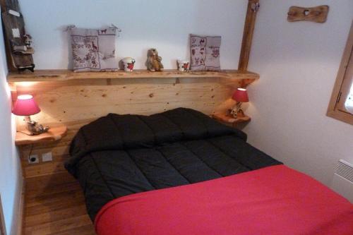 une petite chambre avec un lit et une tête de lit en bois dans l'établissement Appartement chaleureux, 4 personnes, 1 chambre, 1 coin montagne - ISALINE07, à Beaufort