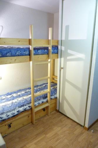 Cette chambre comprend 2 lits superposés et une porte. dans l'établissement Appartement centre village, 4 personnes, 1 chambre, 1 coin montagne - VLI24, à Beaufort