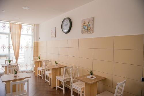 a restaurant with tables and chairs and a clock on the wall at ARTEMIDE "Fiore Club" B&B SUITE SPA in Giffoni Valle Piana