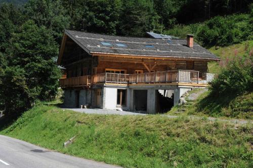 une grande maison en bois sur une colline à côté d'une route dans l'établissement Chalet haut de gamme, 13 personnes, 5 chambres - CH30, à Beaufort