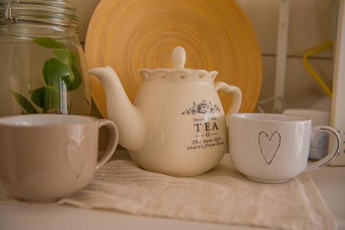 a teapot and two cups on a table at ARTEMIDE "Fiore Club" B&B SUITE SPA in Giffoni Valle Piana