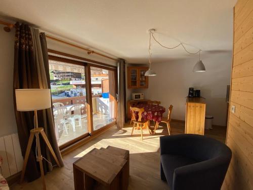 un salon avec un canapé et une table avec des chaises dans l'établissement Appartement cosy, 6 personnes, 2 chambres - MER11, à Beaufort