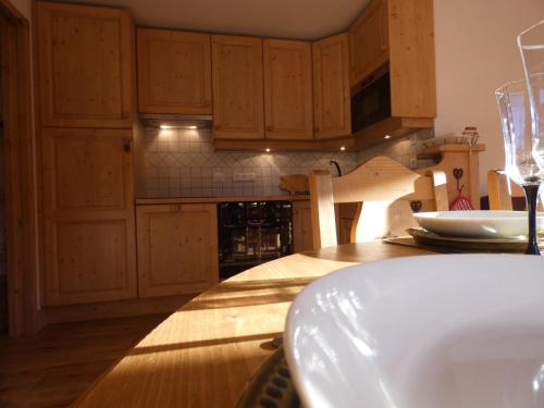 une cuisine avec des placards en bois et une table avec un verre de vin dans l'établissement Appartement lumineux, 6 personnes, 2 chambres - PERLE04, à Beaufort