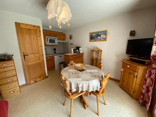 une cuisine avec une table et des chaises et une télévision dans l'établissement Appartement pied des pistes, 4 personnes, 1 chambre - MONT02, à Beaufort